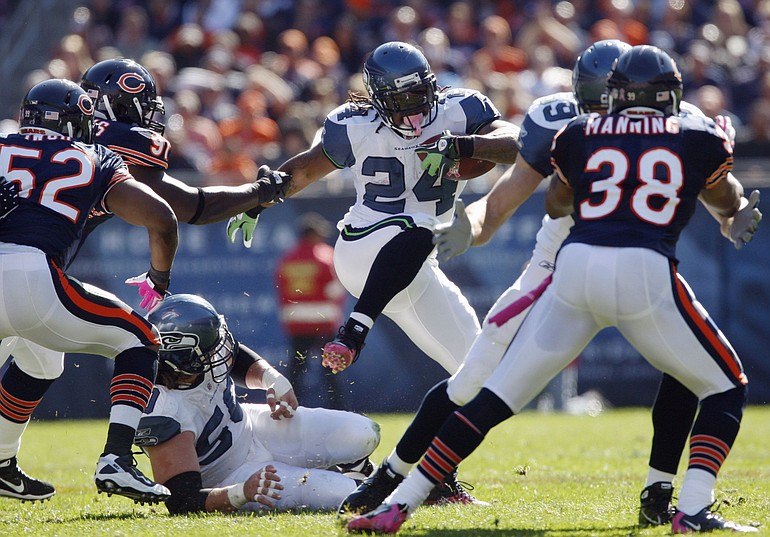 Seattle Seahawks running back Marshawn Lynch (24) gains yards as Chicago Bears defenders Brian Iwuh (52), Tommie Harris (91) and Danieal Manning (38) close in during the first half Sunday.