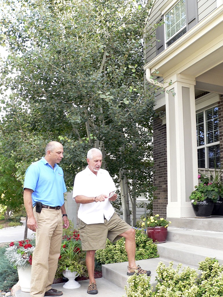 Jon Elliott of Swingle Lawn, Tree &amp; Landscape Care, left, talks with Kemper Smith about the aspen trees growing too close to his Golden, Colo., home.