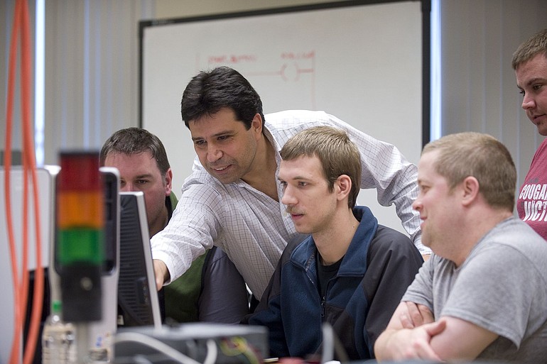Associate professor Hakan Gurocak, second from left, helps Washington State University Vancouver engineering students, from left, Trevor Pope, Todd May, Steven Gehlhausen and Ben Gross, with a lesson in the WSUV automation lab he has developed from scratch.