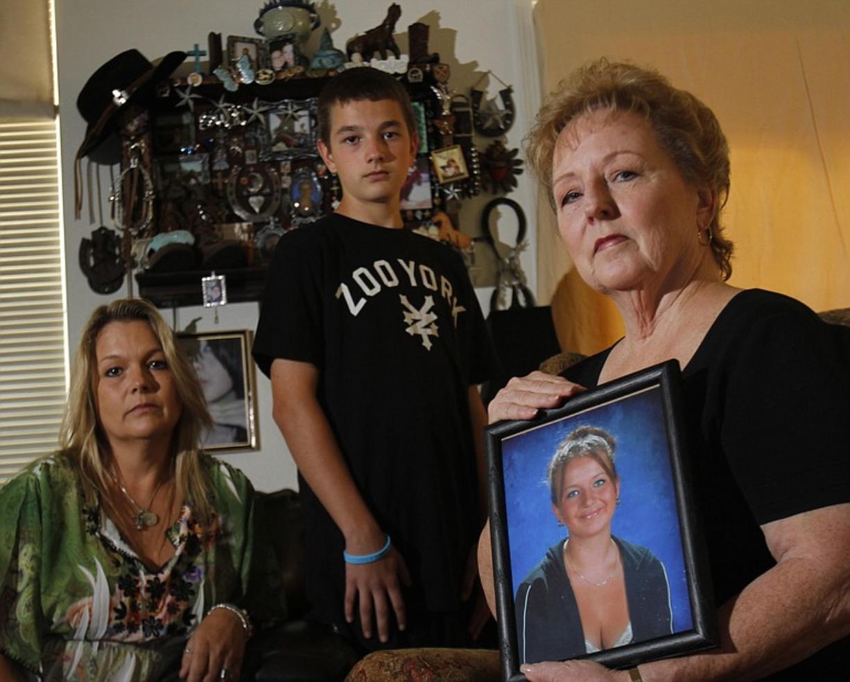 Sylvia Johnson, right, grandmother of a Vancouver teenager murdered  in 2005 by a man whose earlier third-strike life sentence had been rescinded, holds a photo of Chelsea Harrison at her home in in Foothill Ranch, Calif. The family, including Chelsea's brother, Chris Harrison, 15, and her mother, Stephanie Johnson, left, keep a shrine of Chelsea's awards and pictures on the wall.