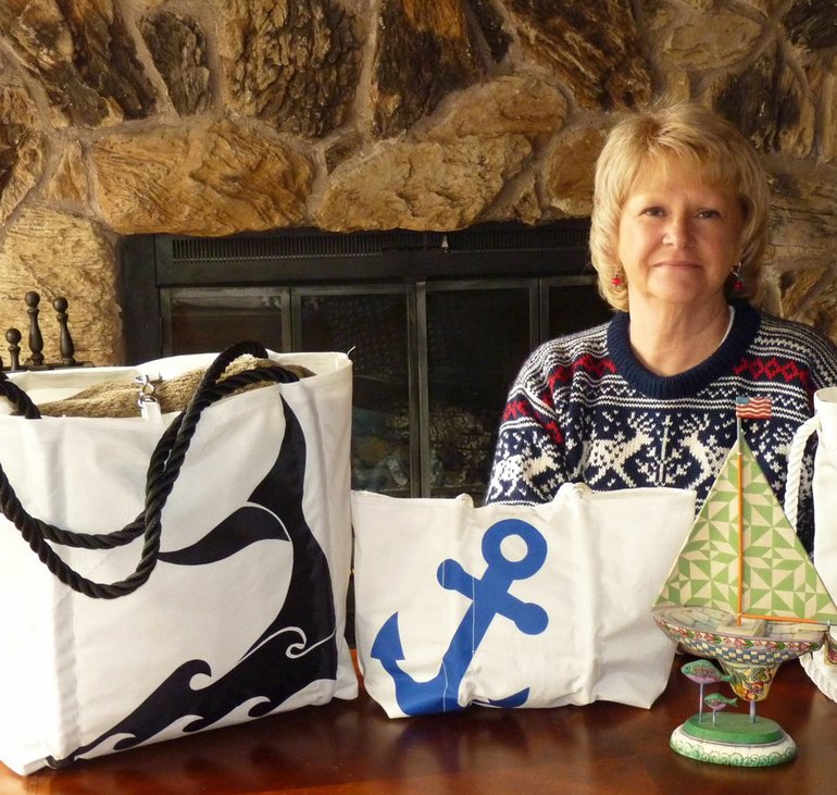 Sue Anderson, co-owner of Second Chance Sails, shows several bags that her business sells.