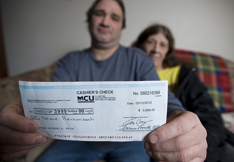 Steve and Alice Reichenbach show a fraudulent &quot;cashier's check&quot; sent by a scam artist offering a job.