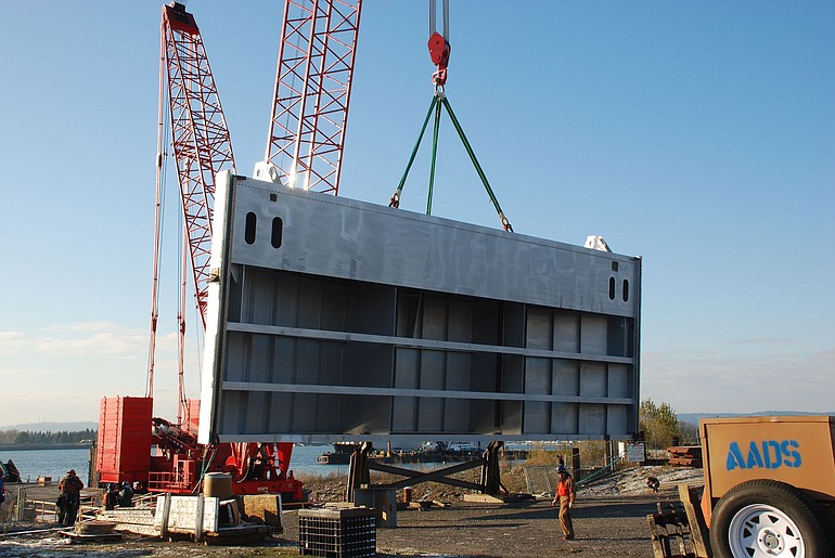 Crews load the final section of the new John Day navigation lock downstream gate at the east slip of the Columbia Business Center in Vancouver.