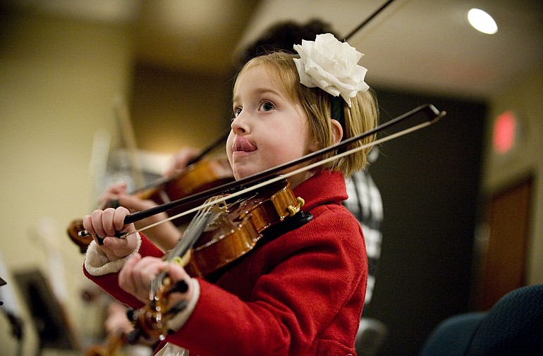 Claire McBride, 5, from Camas, takes a group violin lesson Dec.