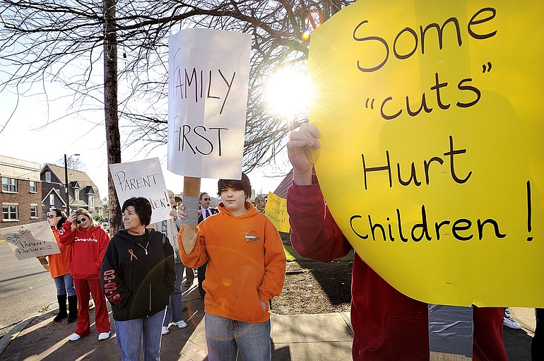 Debbie Conway's 13-year-old son, Cory Hayden, center, stands in protest of Gov. Chris Gregoire's budget proposal that could eliminate his mom's job.