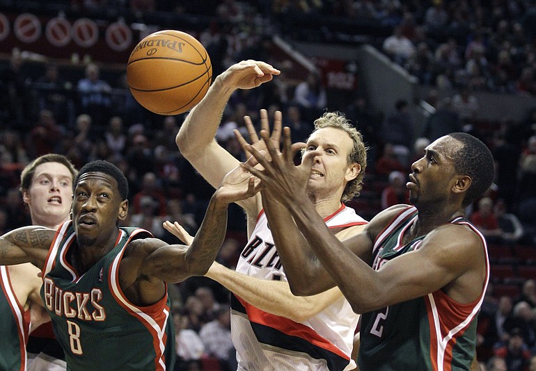 Milwaukee Bucks Larry Sanders (8) and teammate Luc Richard Mbah a Moute, right, battle for a loose ball with Portland Trail Blazers Sean Marks, center, in the fourth quarter during their NBA basketball game Monday, Dec. 20, 2010, in Portland, Ore. The Trail Blazers defeated the Bucks 106-80.