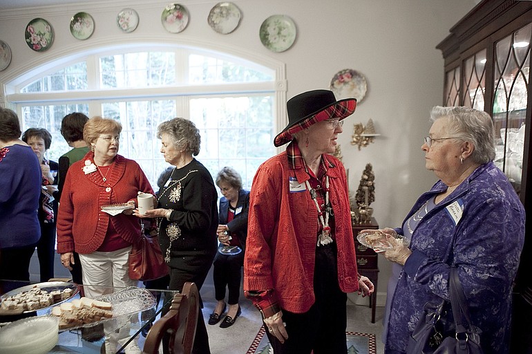 Patti Amerine, far right, speaks with Marlys Stellingwerf at the Clark County Newcomers Club meeting this month. Members and guests mingle over coffee and treats at Susie Bauder's Proebstel home.