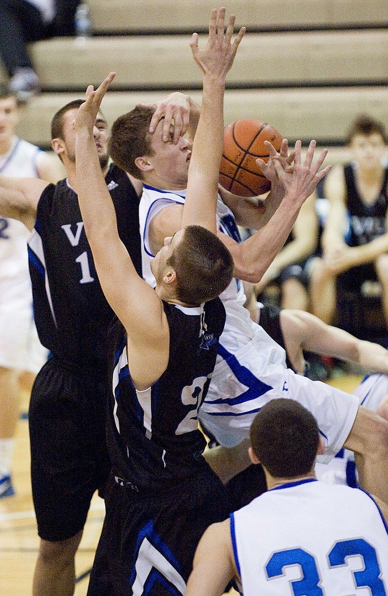Clark College's Daniel Anderson is fouled as he drives through Vancouver Island University defenders.