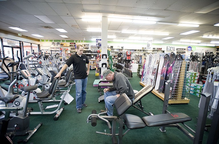 Dan Robinson, right, shops for a weight bench with help from Play It Again Sports employee Don Mershon.