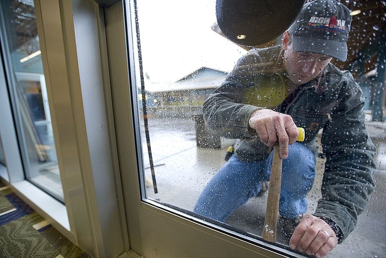 Anderson Glass employee Mike Gilbert replaces glass in an exterior door at the Marshall Center.