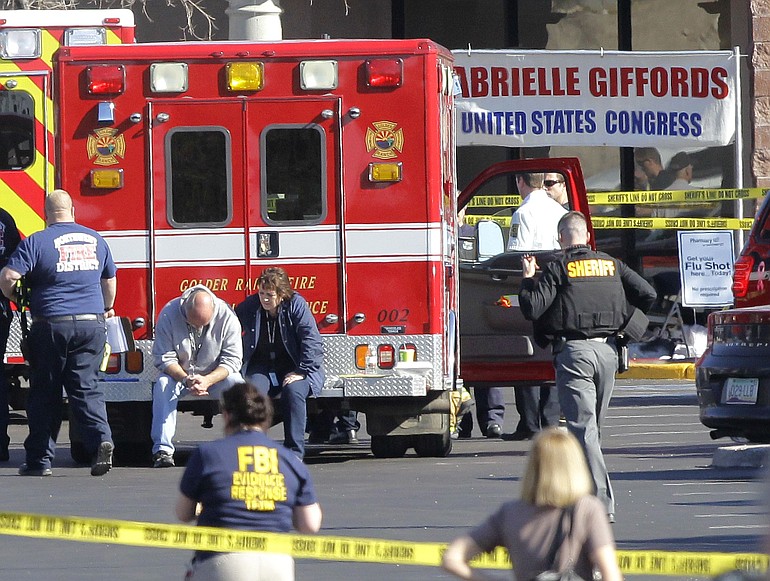 Emergency personnel work at the scene where Rep. Gabrielle Giffords, D-Ariz., and others were shot outside a Safeway grocery store in Tucson, Ariz.