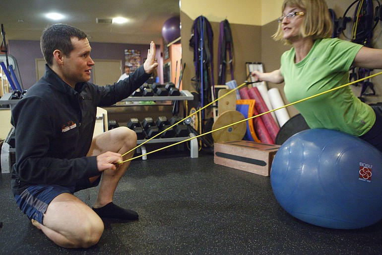Derrick deLay, a personal trainer at Northwest Personal Training in Vancouver, instructs Amanda Otto during her half-hour workout session.