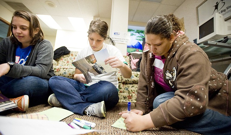 Zoe Brown, a 13-year-old Covington Middle School student, right, with volunteers Annie Burnette, left, and Kaitlynn Jaeger make cards for the homeless during the United Way's Martin Luther King Jr.