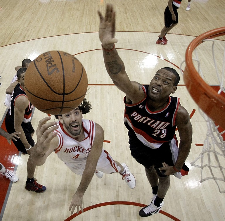 Houston Rockets' Luis Scola (4), of Argentina, shoots as Portland Trail Blazers' Marcus Camby (23) defends during the first quarter of an NBA basketball game Wednesday, Jan. 5, 2011, in Houston. (AP Photo/David J.