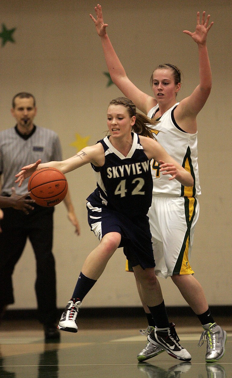 Skyview center Katie Swanson (42) reaches for the ball as Evergreen forward Tori Conley (R) defends during first half of girl's basketball game at Evergreen.