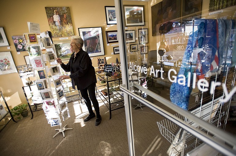 Kathy Winters, member and former president of Alcove Art Gallery in Ridgefield, looks through a rack of cards in the 150-square-foot space.