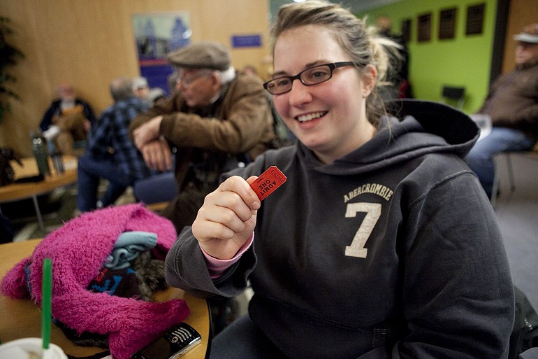 Erica Zachariasen shows off the ticket she earned camping outside the Marshall Community Center Monday night that gave her the fourth pick of dates to reserve a picnic shelter this summer.