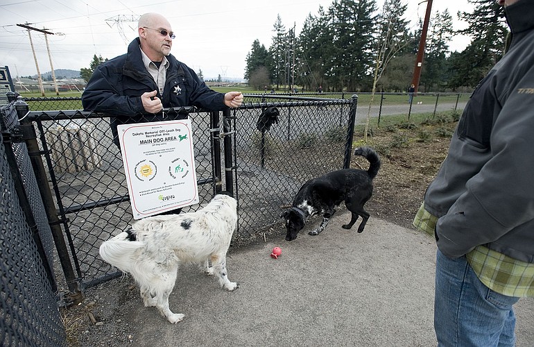 Clark County Animal Control Officer Bill Burrus tells a dog owner that pets must be on a leash outside the off-leash area of Pacific Community Park, Monday, January 31, 2011.