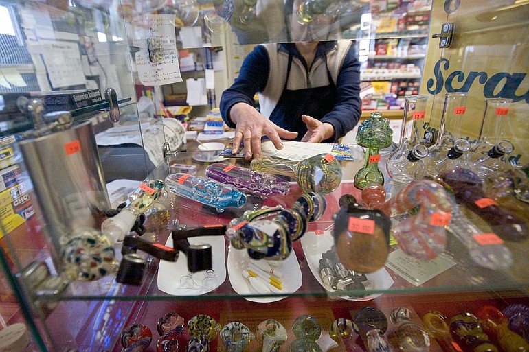 Yan Chiu, owner of Sunny Market on Northeast Minnehaha Street, shows off a selection of glass smoking pipes.