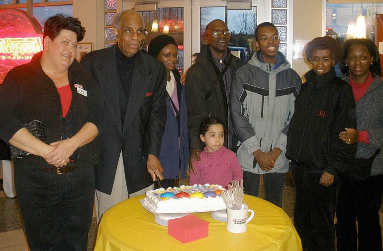Val Martinez, Krispy Kreme general manager, left, helps Harold Franklin and his family celebrate Franklin's retirement after 7 years at the doughnut shop.
