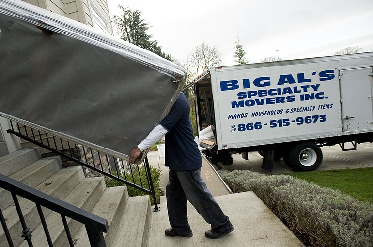 Luka Tapuaialupe, with Big Al's Specialty Movers Inc., helps move a sofa.
