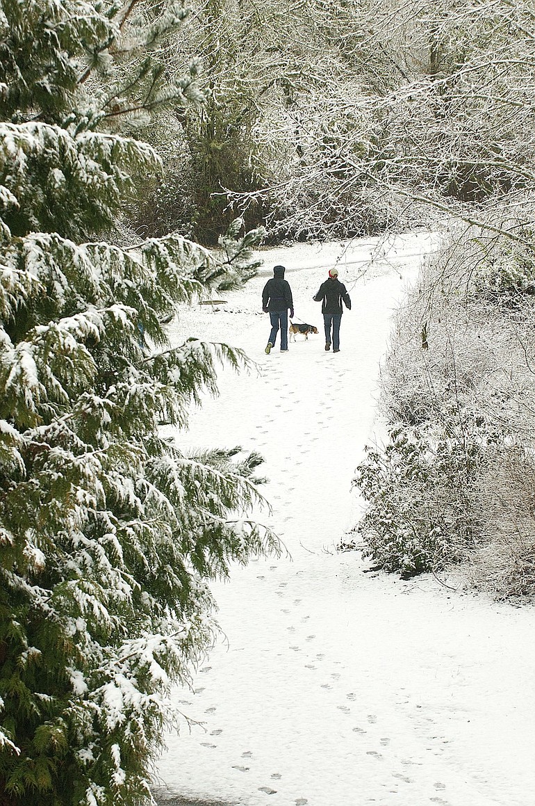 Karen Conway and Margaret Lee, right, walk along the Salmon Creek Trail on Wednesday with Conway's beagle, Daisy.