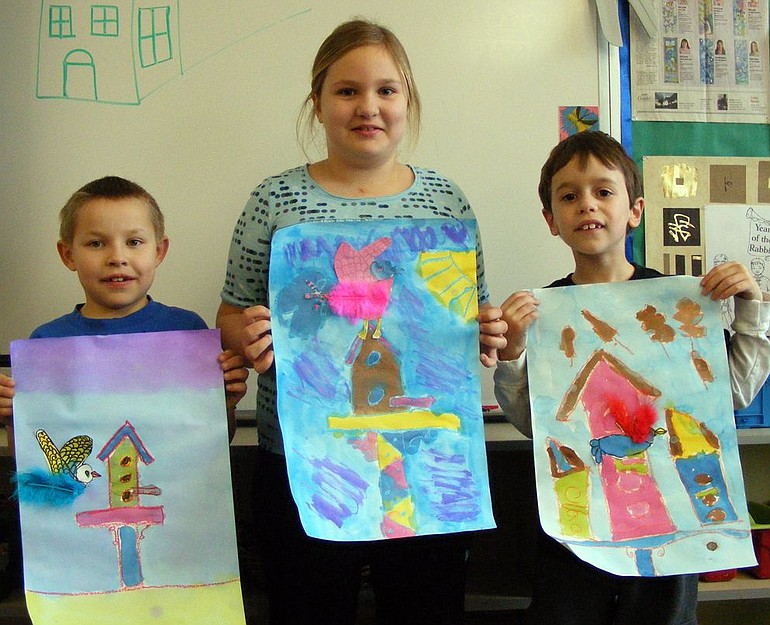 Tukes Valley Primary second-graders, from left, Trevor Sarkinen, Laura Peldo and Michael Piazza, hold up their artwork that will be on display in a help-the-birds exhibit opening Wednesday evening and running one week.