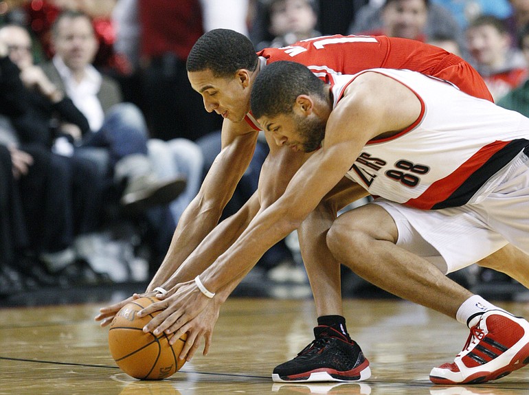 Houston Rockets' Kevin Martin and Portland Trail Blazers' Nicolas Batum (88), of France, dive for a loose ball in the third quarter during an NBA basketball game Tuesday, March 1, 2011, in Portland, Ore. The Rockets defeated the Trail Blazers 103-87.