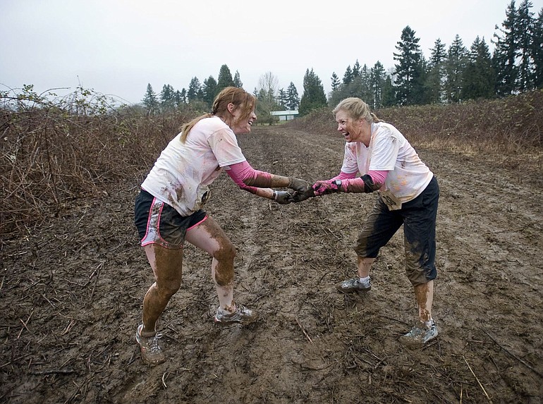 Tiffany Taylor, left, 22, and her mother Cindy Shrum, 48, try to get some extra mud on each other at the March Muddy Madness.