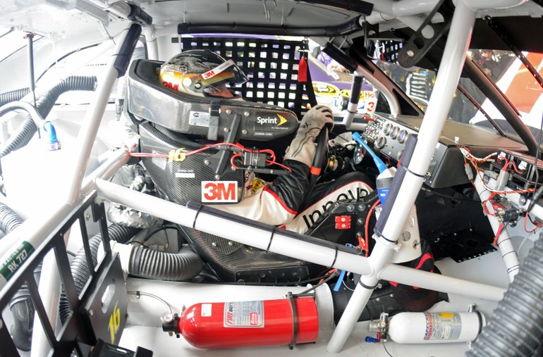 Greg Biffle's office is filled with safety gear to protect him in the event of a crash. He sits quietly in the car as his team works on the chassis during preparations for the Subway Fresh Fit 500 the weekend of Feb.