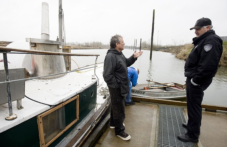 Homeowner/boat owner Lance Balderree talks with Clark County sheriff's Sgt. Fred Neiman at the Ridgefield Marina, on Wednesday.