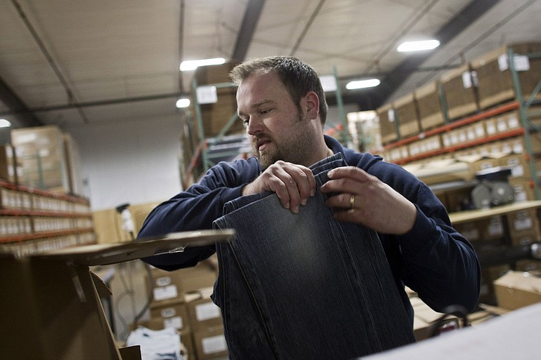 Scott Bauer inpects jeans before shipping them from Agave Denim's Ridgefield warehouse in Ridgefield.