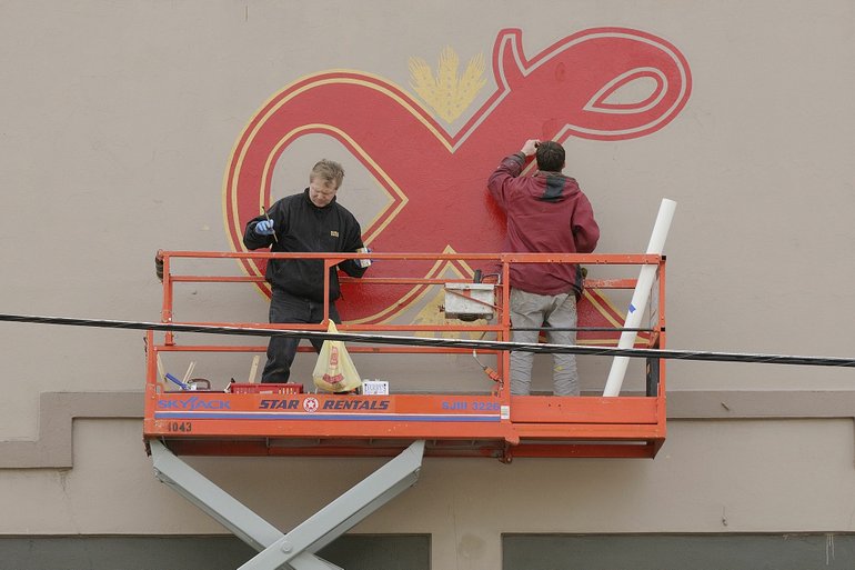 Heath Dewallace and Mike Starks of Soha Signs in Vancouver paint a replica of the Lucky Lager logo that once towered over downtown Vancouver.