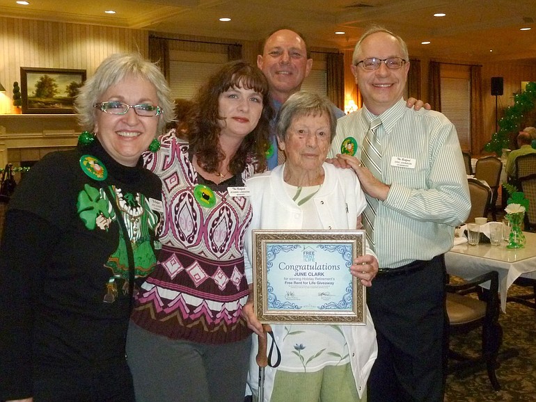 June Clark, holding certificate, won free rent for life at The Bedford retirement community.