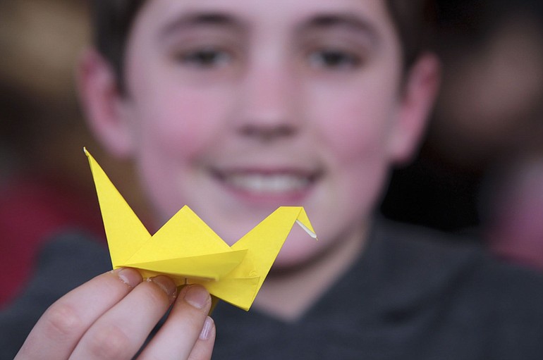 Gabe Brye, 13 shows off an origami crane he made at Pop Culture on Sunday.