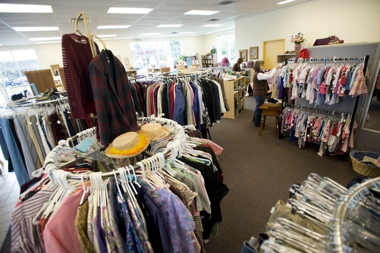 Volunteer Wendy Loyd stocks clothes racks Wednesday at the Second Chance Thrift Store in Vancouver,