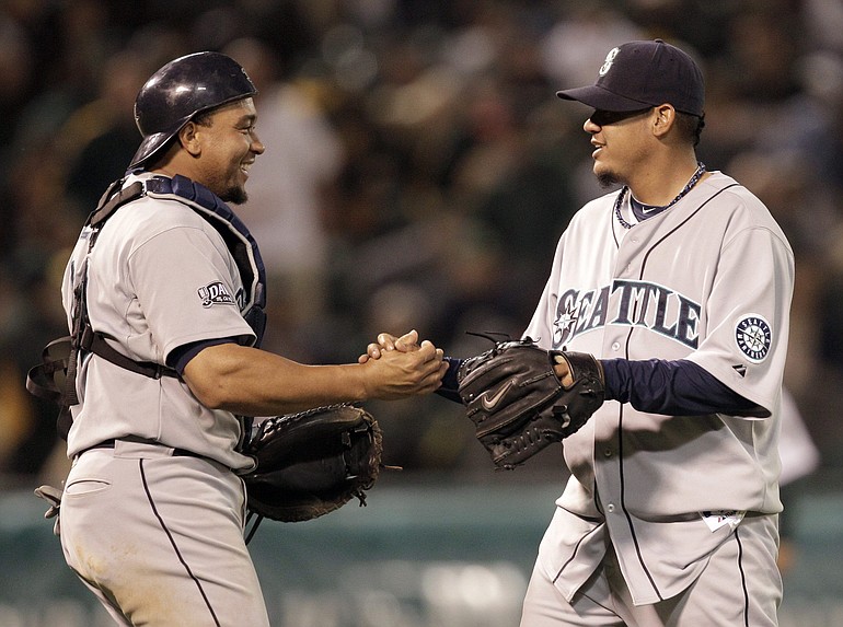 Seattle Mariners' Felix Hernandez, right, is congratulated by catcher Miguel Olivo after the the 6-2 defeat of the Oakland Athletics on Friday.