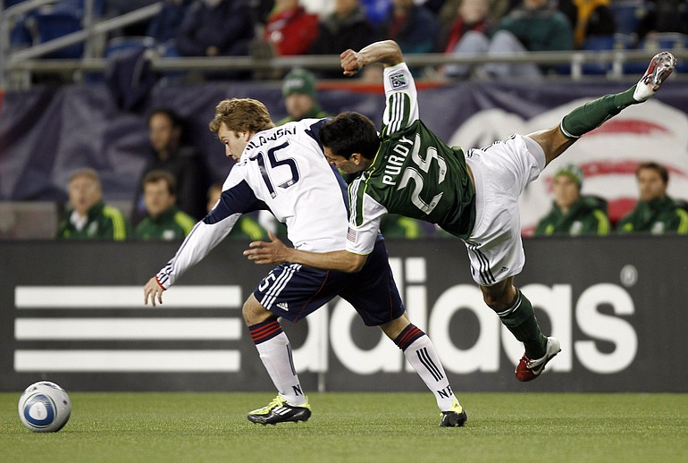 New England Revolution's Zach Schilawski (15) upends Portland Timbers' Steve Purdy during the first half at Gillette Stadium in Foxborough, Mass., on Saturday.