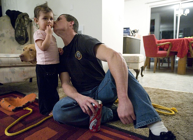 Alan Northrop, 46, gives his granddaughter, Jayda, a kiss at their Ridgefield apartment on an evening this winter. Both his daughter and granddaughter live with him in a two-bedroom apartment.