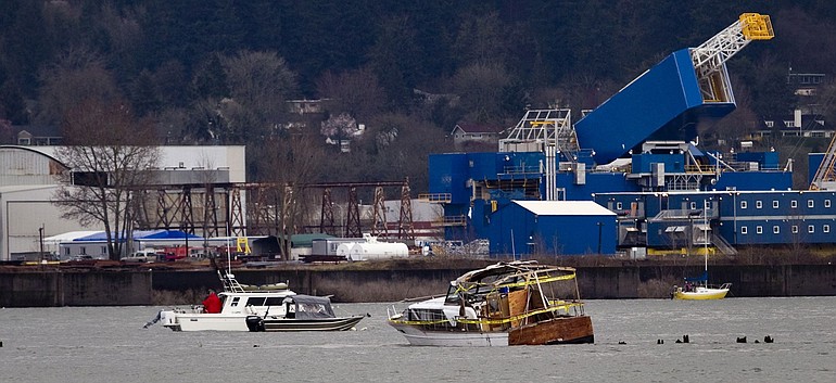 A 32-foot boat, right foreground in the Columbia River on March 28, apparently flipped over and may have disintegrated.