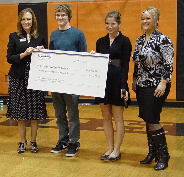 Lacamas Community Credit Union President/CEO Kathleen Romane, from left, presents a check for $3,000 to Washougal High School students Hunter Ringsage and Aviv Bressler as LCCU Washougal Branch Manager Darcie Williams looks on.