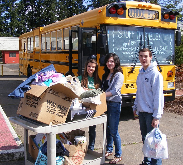 Pleasant Valley Middle School student body leaders, from left, Brielle Lindsay, Keiko Inouye and Jordan Halverson load food and other items aboard a school bus for the trip to SHARE, a Vancouver-based charity for the homeless and needy.