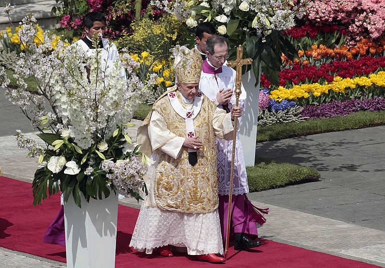 Pope Benedict XVI walks with his pastoral staff towards the altar to deliver an Easter Mass in St. Peter's Square, at the Vatican, Sunday, April 24, 2011. Benedict XVI urged an end to fighting in Libya, using his Easter Sunday message to call for diplomacy and peace in the Middle East. At right is Mons.