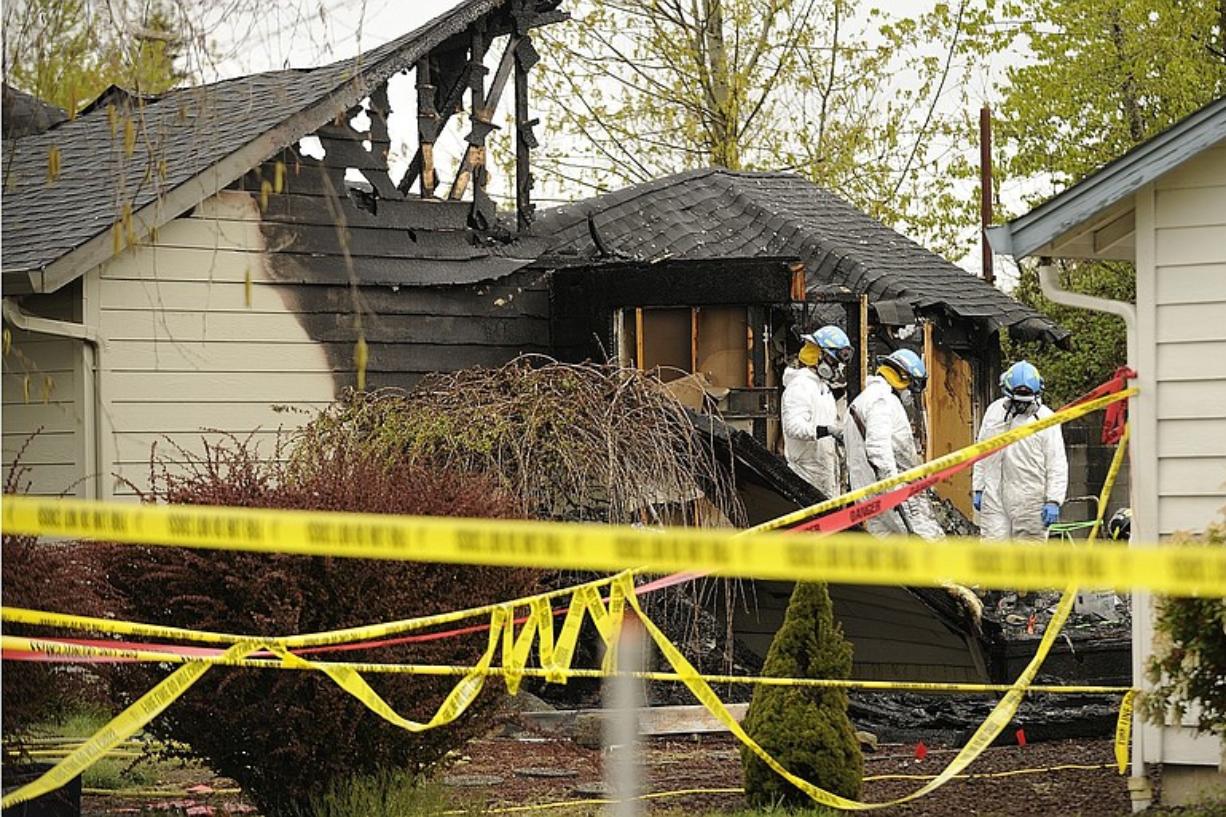 Vancouver Fire Arson Team and agents with ATF look through the burned remains of a fatal house fire during their investigation Monday.