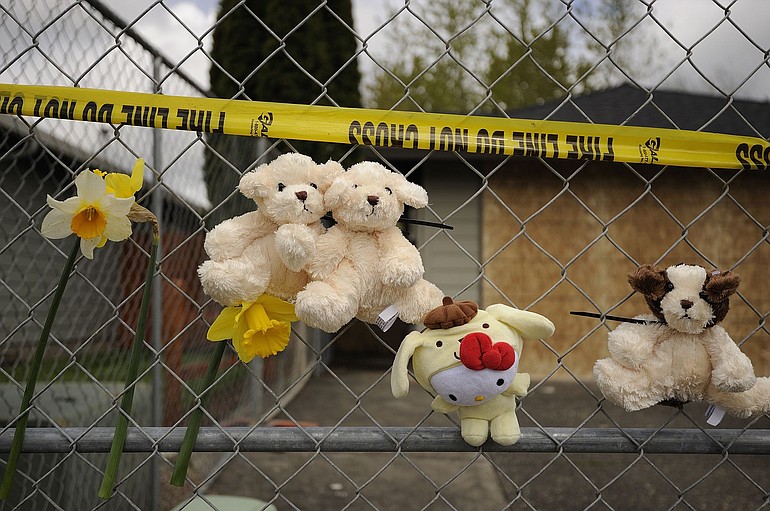 Flowers and toys serve as a memorial outside the home where six people died in an Easter morning fire in Vancouver.