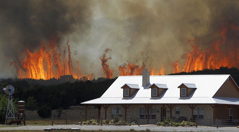 A wildfire threatens a house near Possum Kingdom, Texas, on April 19.