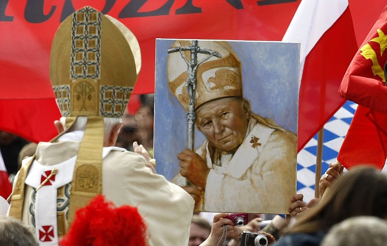 Pope Benedict XVI drives past a picture of late John Paul II in St. Peter's Square at the Vatican, Sunday, May 1, 2011. Pope Benedict XVI beatified Pope John Paul II before more than a million faithful in St.