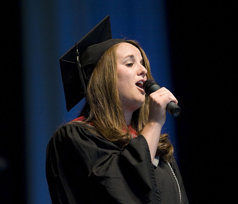 Washington State University Vancouver graduate Amanda Goebel sings the national anthem at Saturday's commencement ceremony after dedicating the anthem to her husband, a Marine who is training for deployment to Afghanistan early next year.