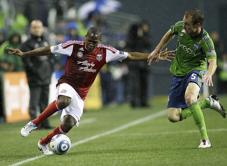 Portland Timbers' Darlington Nagbe, left, tries to drive around Seattle Sounders' Tyson Wahl (5) in the first half Saturday at Qwest Field.