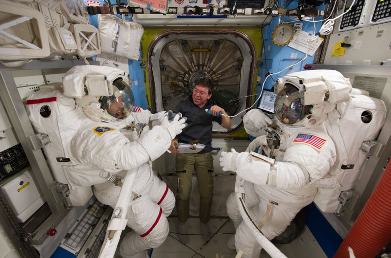 Discovery astronauts Steve Bowen, left, Mike Barratt, center, and Alvin Drew in the Quest airlock of the International Space Station as they prepare for STS-133's first spacewalk on Feb.